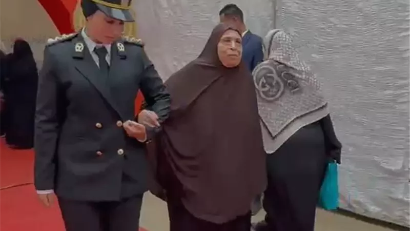 الشرطة تساعد مسنًة أثناء تصويتها في أول أيام انتخابات النواب بحدائق القبة 