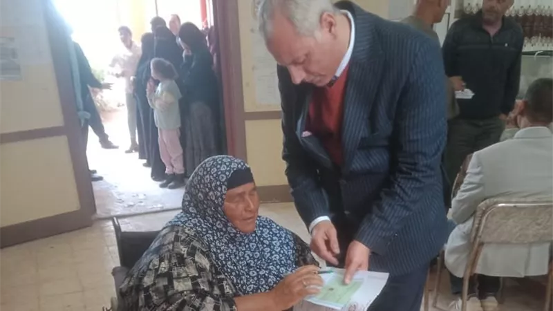 رئيس لجنة يساعد مسنة قعيدة للإدلاء بصوتها في كفر الشيخ