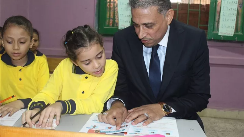 بمشاعر الأبوة.. «وكيل تعليم الجيزة» يجلس بجانب تلميذة على المقعد في أول يوم دراسة