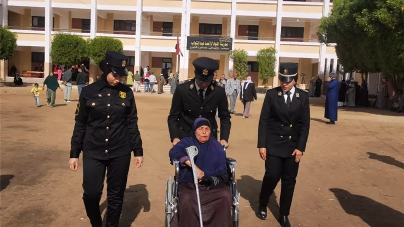 الشرطة النسائية تسجل حضورها بمساعدة مسنة أثناء التصويت بالفيوم