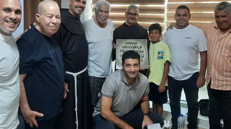 الأب بطرس دانيال يهدي حسن شحاتة لوحة من الصدف تحمل بداخلها آيات من سورة الفلق